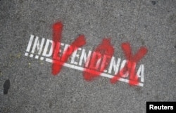 FILE - The name of the Spanish right-wing party Vox is sprayed over the graffiti stencil reading "Independence" on sidewalk in Barcelona, Spain, Dec. 12, 2018.