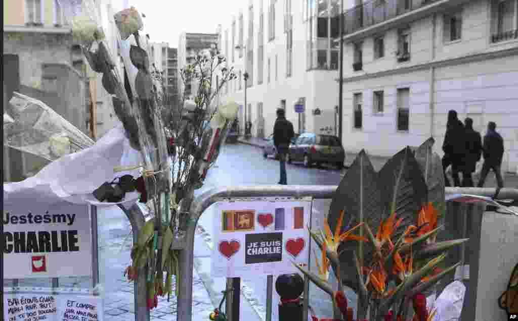 Karangan bunga di pagar pengaman di luar kantor pusat&nbsp;Charlie Hebdo seminggu setelah serangan terhadap tabloid itu, di Paris, Perancis (14/1). ​(AP/Jacques Brinon)