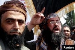 FILE - Members of Jordan's Salafi jihadi shout slogans during a demonstration against prolonged detention of the group's leaders in Amman, Jordan, April 9, 2013.