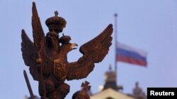 រូបឯកសារ៖ រូប​សត្វ​តន្ទ្រី​ក្បាល​ពីរ​ដែល​ជា​សញ្ញាណ​នៃ​ប្រទេស​រុស្ស៊ី នៅ​ចំពី​មុខ​ទង់ជាតិ​រុស្ស៊ី​នៅ​ពី​លើ​ដំបូល​សារមន្ទីរ​ជាតិ Hermitage នៅ​ទីក្រុង St. Petersburg កាល​ពី​ថ្ងៃទី១ ខែ​វិច្ឆិកា ឆ្នាំ​២០១៥។ (REUTERS/Peter Kovalev)