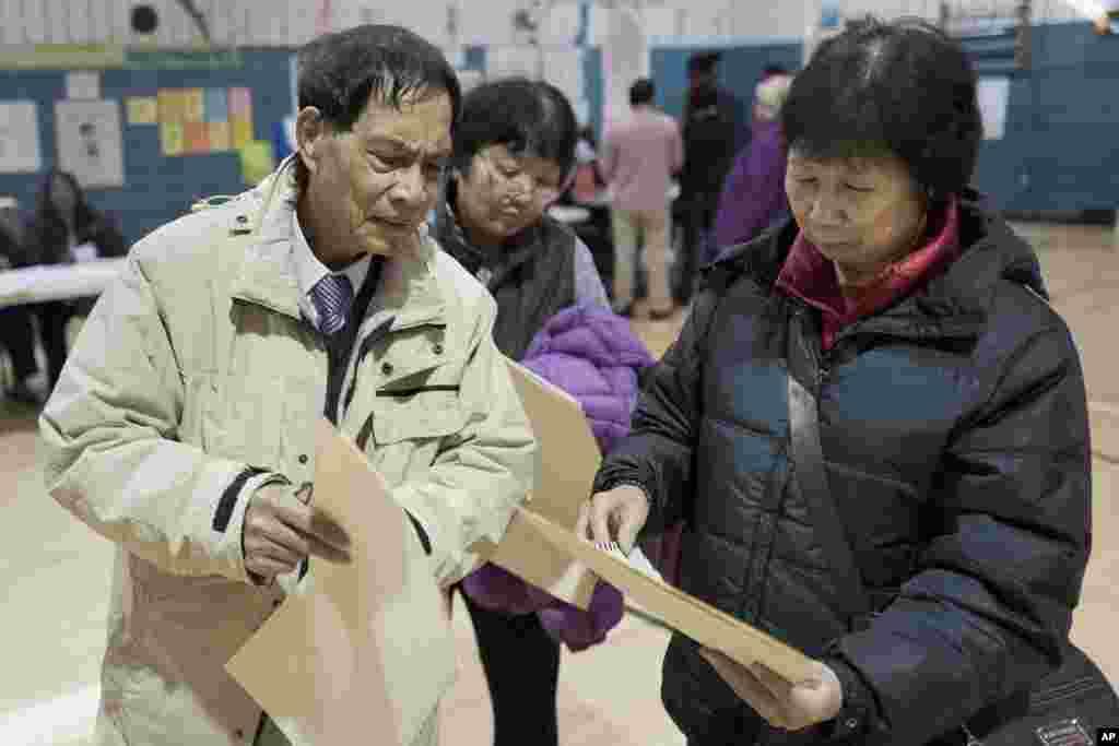Zhou Nan Zhou, left, and his wife, Li Li Tan, study their ballots in the Sunset Park neighborhood in the Brooklyn borough of New York.