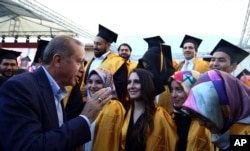 FILE - Turkey's President Recep Tayyip Erdogan speaks with students at the Sabahattin Zaim University in Istanbul, June 5, 2016.