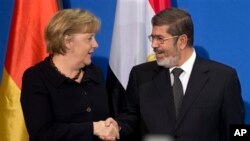 Presiden Mohamed Morsi (kanan) bertemu Kanselir Angela Merkel dalam kunjungan singkat ke Berlin, Jerman hari Rabu (30/1). 