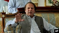 Former prime minister and leader of Pakistan Muslim League-N party, Nawaz Sharif, gestures while speaking to members of the media at his residence in Lahore, Pakistan, May 13, 2013.