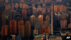The setting sun illuminates residential buildings in eastern Beijing, as seen from the top of the China World Trade Center Tower 3