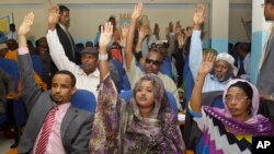 Somalia lawmakers raise their hands during a confidence vote on Prime Minister Abdiweli Sheikh Ahmed, at the Parliament Building in Mogadishu, Somalia, Dec. 6, 2014.