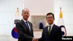 David Stilwell, asisten Menlu AS untuk urusan Asia Timur dan Pasifik (kiri) berjabat tangan dengan Asisten Menlu Korsel, Cho Sei-young di Seoul, Korsel, 6 November 2019. (Foto: dok).