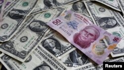 FILE - A picture illustration shows Mexican pesos and U.S. dollars banknotes in Mexico City.