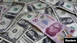 FILE - A picture illustration shows Mexican pesos and U.S. dollars banknotes in Mexico City.