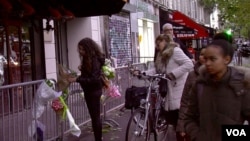 Parisians stop in front of the Bataclan concert hall, which reopens Saturday night. (L. Bryant/VOA)