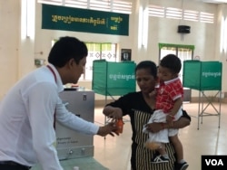 FILE: A Cambodian women inks her finger after casting her ballot at a polling station in Takhmao city, just outside of Cambodia's capital of Phnom Penh, Sunday, July 29, 2018. (Sok Khemara/VOA Khmer)