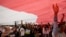 People wear T-shirts that read "Replace the President in 2019" stand under a large national flag during a rally in Jakarta, Indonesia, May 6, 2018. 