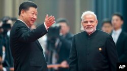 Chinese President Xi Jinping, left, welcomes Indian Prime Minister Narendra Modi for a meeting at the Shanghai Cooperation Organization (SCO) Summit in Qingdao in eastern China's Shandong Province, June 10, 2018. 