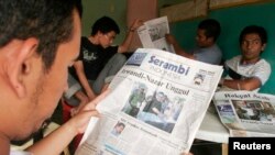 Seorang warga Aceh membaca koran lokal untuk memantau hasil pemilihan gubenur provinsi tersebut. (Foto: Dok)