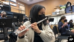 A student plays the flute while wearing a protective face mask during a music class at the Sinaloa Middle School in Novato, Calif., Tuesday, March 2, 2021. (AP Photo/Haven Daily) 