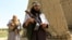FILE - Members of the Taliban walk in Ghanikhel district of Nangarhar province, Afghanistan, June 16, 2018.