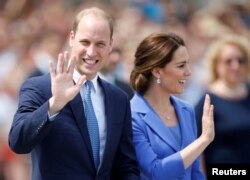 FILE - Prince William, the Duke of Cambridge, and his wife Catherine, the Duchess of Cambridge, visit Brandenburg Gate in Berlin, Germany, July 19, 2017.