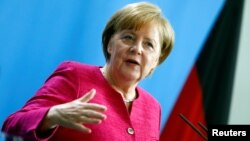 German Chancellor Angela Merkel gestures at a news conference with NATO Secretary-General Jens Stoltenberg in the German Chancellery in Berlin, June 15, 2018.