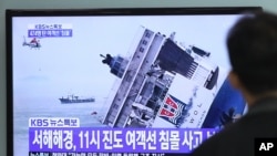 Seorang pria tengah menyaksikan tenggelamnya kapal feri "Sewol" yang ditayangkan melalui siaran televisi di sebuah stasiun kereta api di Seoul, Korea (Foto: dok). Sebuah kapal feri kembali kandas, 70 kilometer dari lokasi tenggelamnya kapal Sewol ini, Selasa (30/9).
