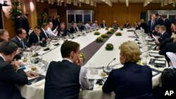 British Prime Minister David Cameron, center left, talks during the round table meeting of European Union heads of state and government at an EU summit in Brussels, Feb. 19, 2016.