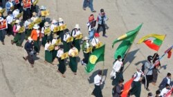 (FILES) In this file photo taken on February 17, 2021 a group of school teachers hold up signs during a demonstration against the military coup in Naypyidaw. - Schools in Myanmar opened on June 1 for the first time since the military seized power, but tea