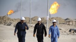Iraqi workers walk in West Qurna oilfield in Iraq's southern province of Basra, November 28, 2010. (Reuters)