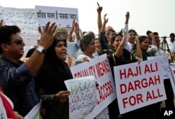 FILE - People shout slogans to support women's rights activists opposing the ban on women entering the Muslim shrine Haji Ali Dargah, in Mumbai, India, Apr. 28, 2016. A Mumbai court lifted the ban on Friday.
