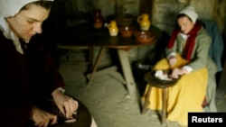 FILE – Reenactors dressed as Pilgrims prepare a meal at Plimoth Plantation in Plymouth, Massachusetts in this 2004 file photo.