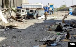FILE - A member of the Yemeni pro-government forces walks through destruction in an industrial district in the eastern outskirts of the port city of Hodeida on Nov. 18, 2018, during the ongoing battle for control of the city from the Houthi rebels.