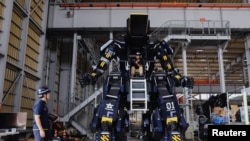 เรียว โยชิดะ และอากิโนริ อิชิอิ ประธานบริหารและประธานฝ่ายเทคนิคของบริษัทซึบาเมะ อินดัสตรี กับหุ่นยนต์ ARCHAX ที่เมืองโยโกฮามา ญี่ปุ่น (ที่มา: รอยเตอร์)