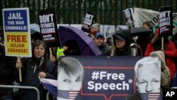 Supporters hold placards and banners during a protest against the extradition of Wikileaks founder Julian Assange outside Belmarsh Magistrates Court in London, Feb. 24, 2020. 