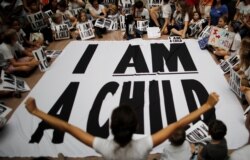 FILE - Children and family members take part in a sit-in following a march to mark the court-ordered deadline for the Trump administration to reunify thousands of families separated at the border, in Washington, July 26, 2018.