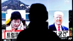 한국 서울역에 설치된 TV에서 박근혜 대통령이 도널드 트럼프 미국 대통령 당선인(오른쪽)과 통화했다는 뉴스가 나오고 있다.