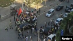 Petugas keamanan berjaga di sekeliling mobil Dubes AS Gary Locke pasca insiden kerumunan demonstran anti-Jepang. Para pengunjuk rasa tersebut melempari mobil Dubes Locke dan menghambat jalan masuk ke Kedubes AS di Beijing (18/9). 