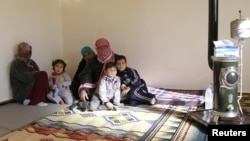 Syrian refugees, who fled the violence in the Syrian town of Qusair, sit at a temporary home, in the hillside town of Arsal in Lebanon's Bekaa Valley, March 5, 2012.