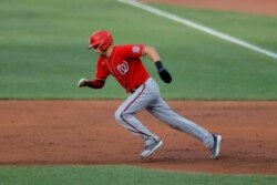 Washington Nationals' Trea Turner tries to steal second base against the Baltimore Orioles during an exhibition baseball game, July 20, 2020, in Baltimore. Turner was caught stealing by catcher Bryan Holaday.
