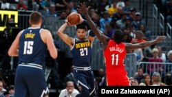Le pivot des Denver Nuggets, Nikola Jokic, à gauche, son coéquipier Jamal Murray , et Jrue Holiday des New Orleans Pelicans, Denver, le 29 octobre 2018.