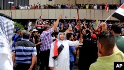 Supporters of Shi'ite cleric Muqtada al-Sadr chant slogans calling for governmental reforms as they wave national flags before ending their sit-in inside Baghdad's highly fortified Green Zone, May 1, 2016.