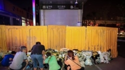 河南郑州市民在被黄色围栏围起来的地铁5号线车站前献花悼念水灾死难者。（2021年7月26日）