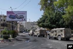 Kendaraan tentara tampak berjejer selama serangan militer Israel di kubu militan di kamp pengungsi Jenin di Tepi Barat yang diduduki, Selasa, 4 Juli 2023. (Foto: AP)