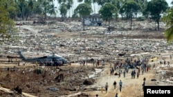 Indonesian tsunami survivors receive food and water from a U.S helicopter in a damaged village in Aceh Jaya district, January 5, 2004.