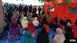 Pejabat pemerintah setempat, IOM dan UNHCR memberikan pengarahan kepada pengungsi Rohingya yang tiba di Kabupaten Aceh Timur, Sabtu, 5 Juni 2021. (VOA/Anugrah)