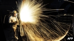 Pekerja memotong baja di Qingdao, selatan Provinsi Shandong, China, 18 Januari 2018.