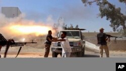 Des combattants islamistes de la Brigade Misarata tirent en direction de l'aéroport de Tripoli dans une tentative d'arracher le contrôle d'une puissante milice rivale à Tripoli , Libye, 26 juillet 2014.