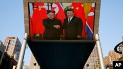 შეხვედრის მომენტი პეკინში დამონტაჟებულ გიგანტურ ქუჩის ეკრანზე.