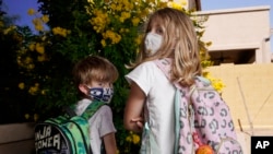 Angela Black, right, with her brother Luke Black at their home, pose for a photo Tuesday, May 11, 2021, in Mesa, Ariz. (AP Photo/Ross D. Franklin)