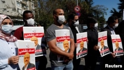 Des gens tiennent des photos du journaliste saoudien Jamal Khashoggi lors d'un rassemblement pour marquer le deuxième anniversaire de son meurtre au consulat saoudien, à Istanbul, en Turquie, le 2 octobre 2020.