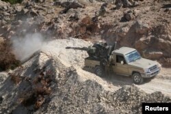 FILE - A fighter of the Syria Democratic Forces mans an anti-aircraft weapon in the southern rural area of Manbij, in Aleppo Governorate, Syria, May 31, 2016.