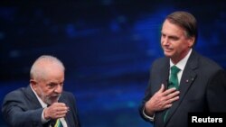 Mantan Presiden Brazil dan kandidat presiden pada pilpres Brazil 2022 Luiz Inacio Lula da Silva (kiri) dan Presiden Brazil dan calon petahana Jair Bolsonaro berbicara dalam debat capres di Sao Paulo, Brazil, pada 16 Oktober 2022. (Foto: Reuters/Mariana Greif)