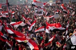 FILE- Egyptians wave national flags and hold pictures of Egypt's Defense Minister Gen. Abdel-Fattah el-Sissi, during a rally in Tahrir Square, in Cairo, Egypt, Saturday, Jan. 25, 2014. (AP Photo/Khalil Hamra)
